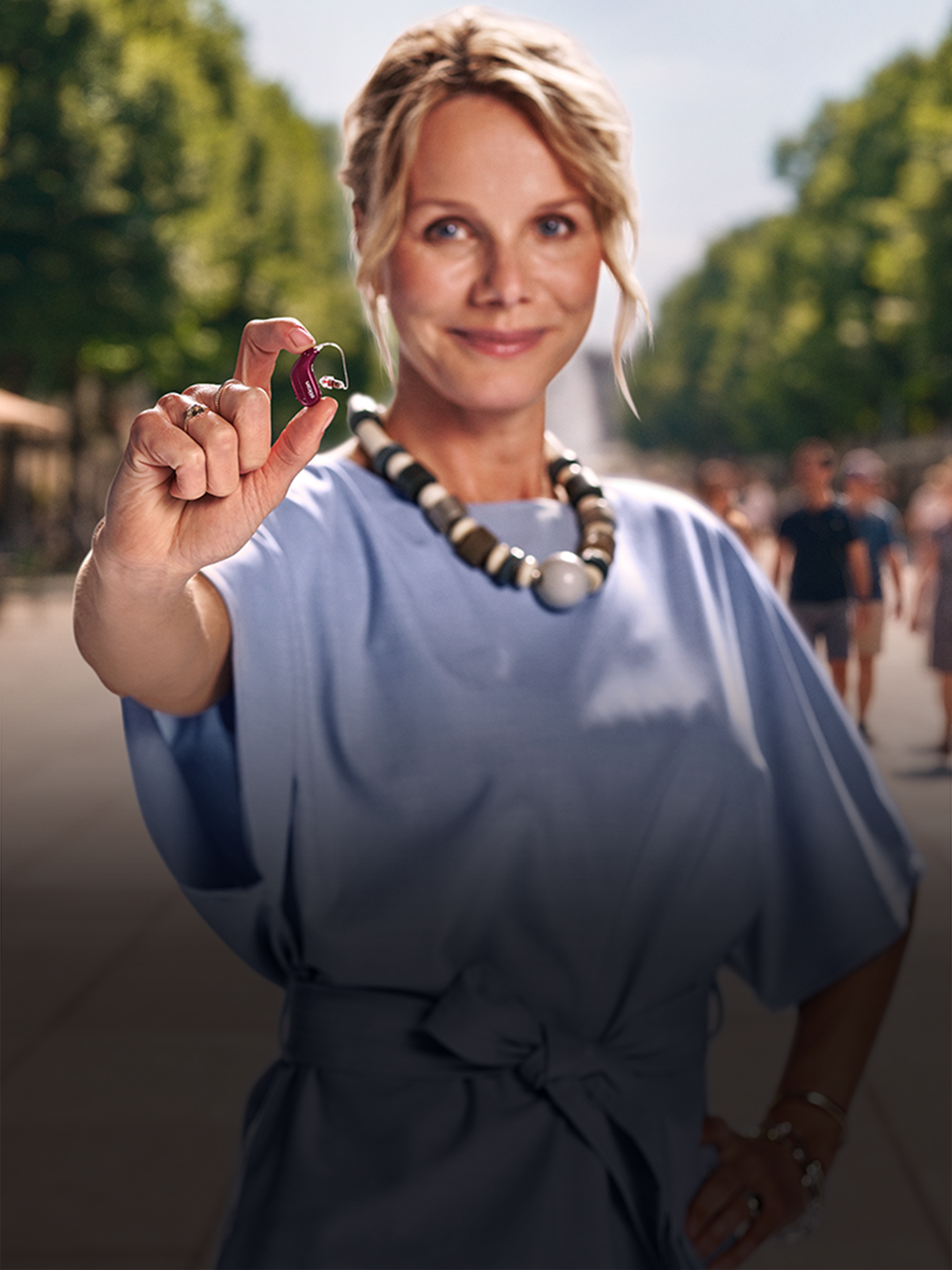 Person hält ein Oticon Reveal Hörgerät in der Hand
