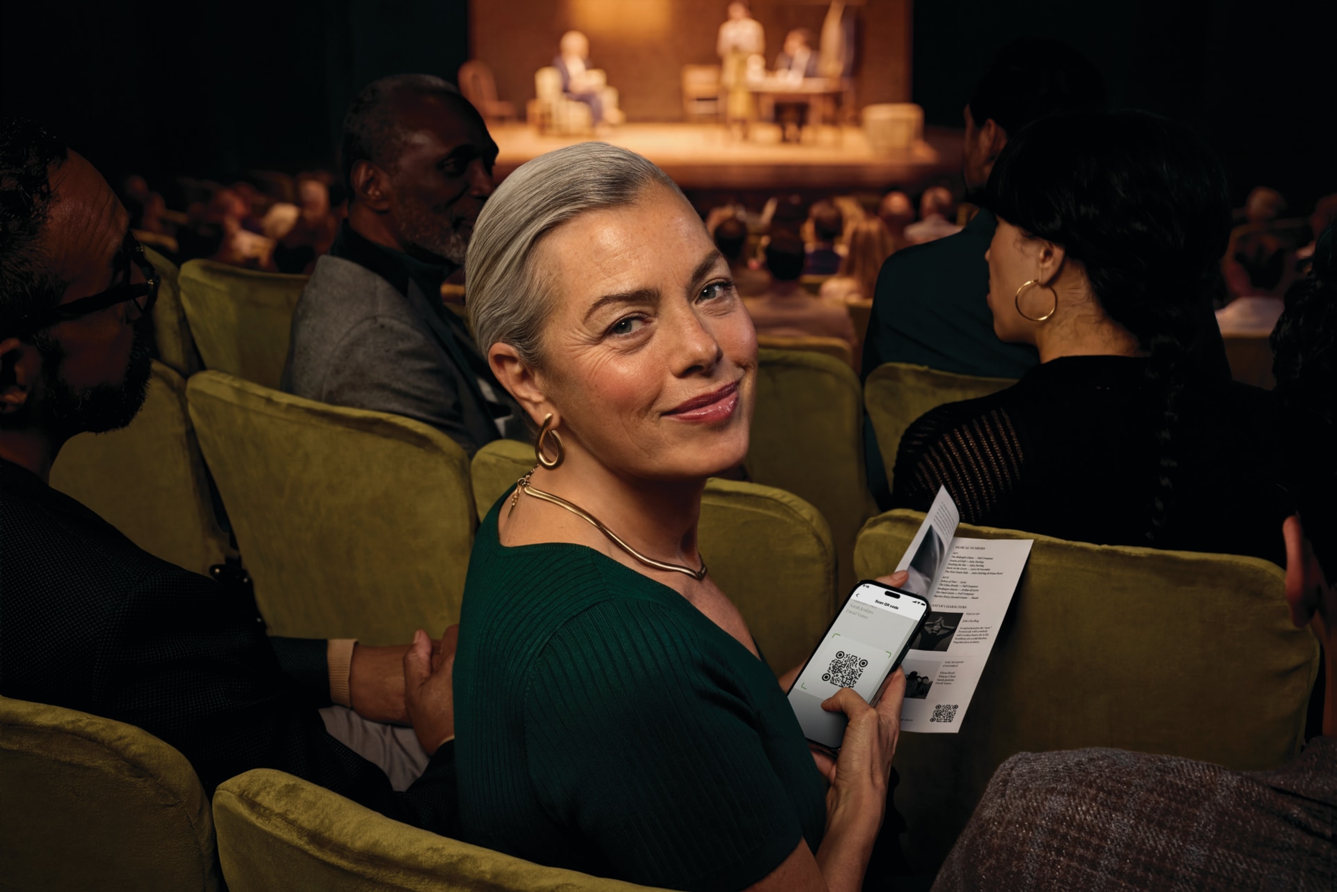 Person im Theater, die Auracast mit Phonak Audéo EON Hörgeräten nutzt